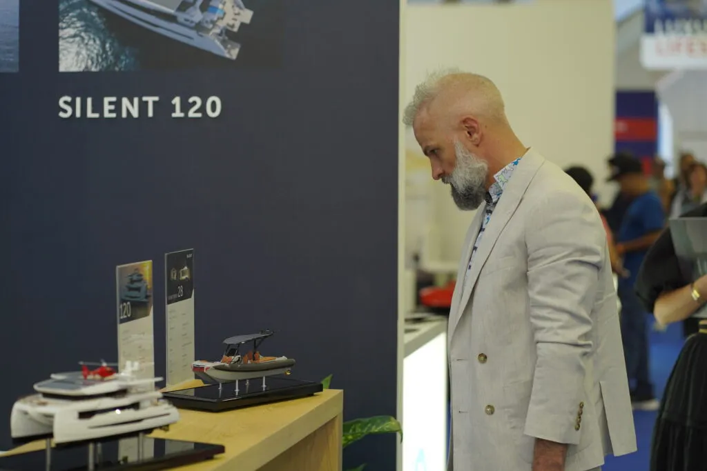 A visitor views a model of the Silent 120 yacht.
