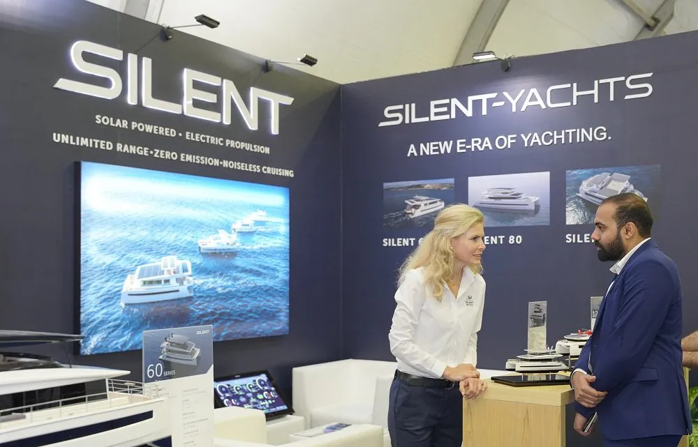 A representative speaks to a visitor at the Silent-Yachts stand.
