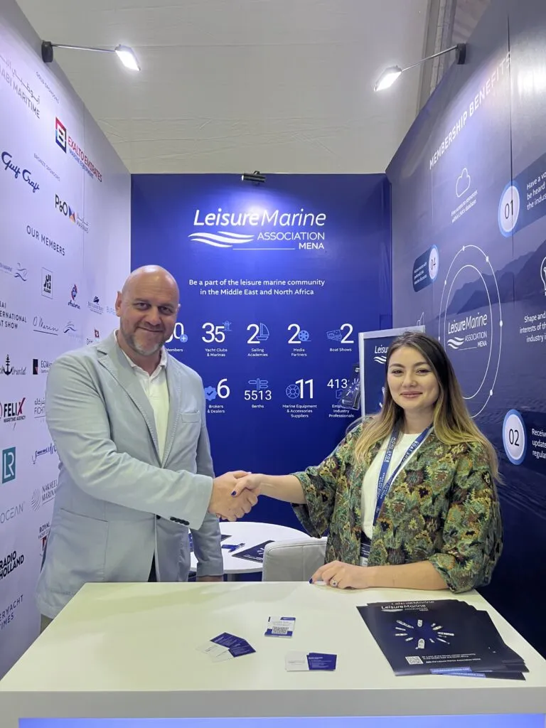 Professional discussing marine services at the LMA MENA booth during the Dubai International Boat Show