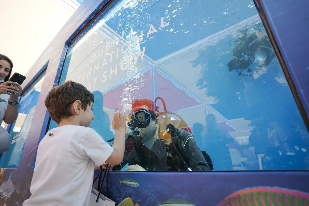 A child interacts with a diver in the dive pool.