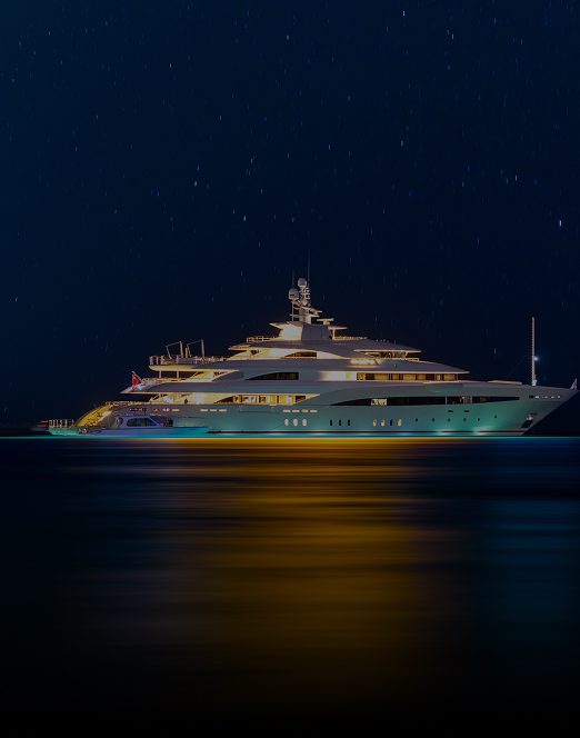 Superyacht lit up at night on the water